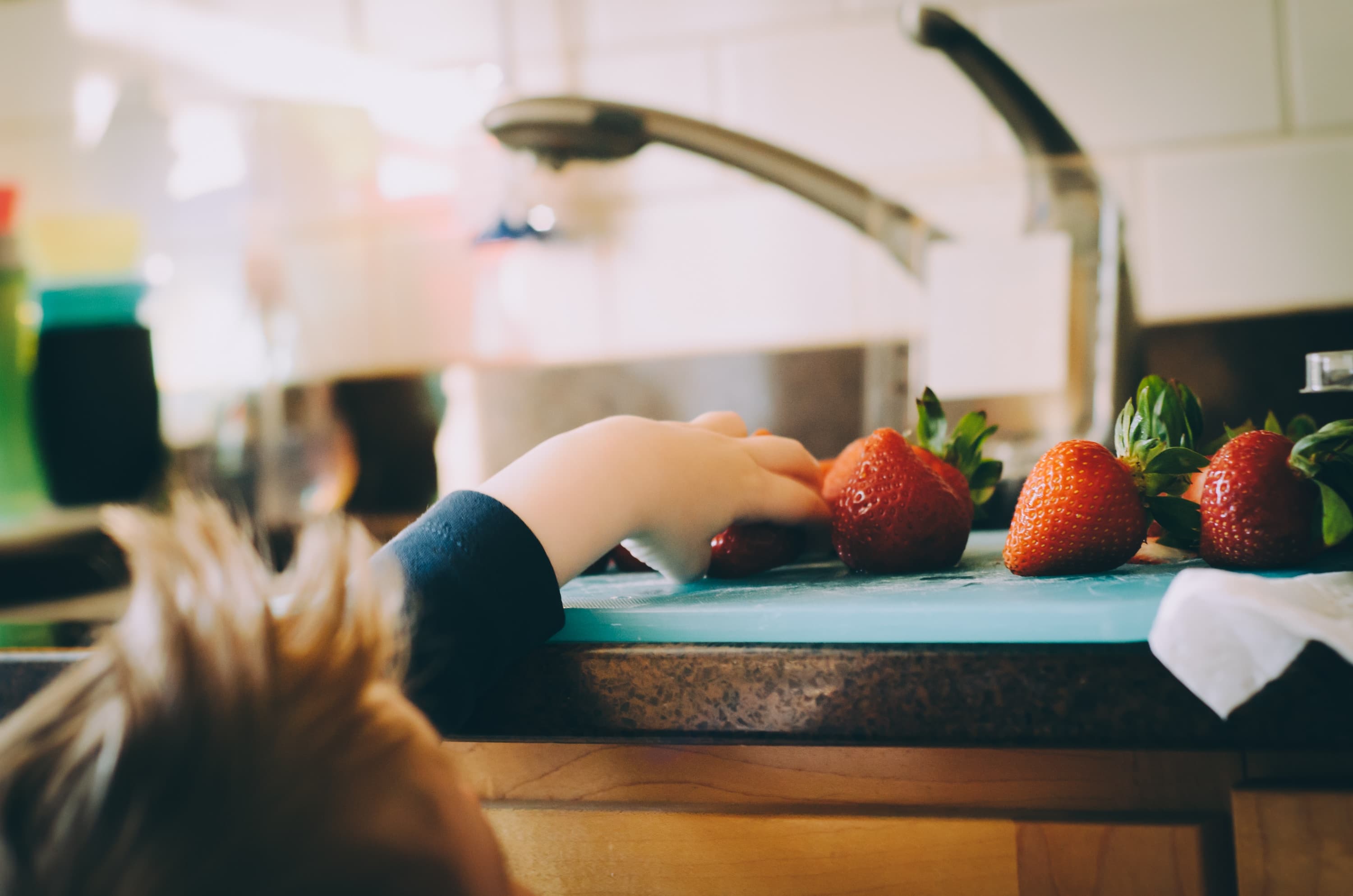 Enfant qui essaye d'attraper une frasie sur le plan de travail