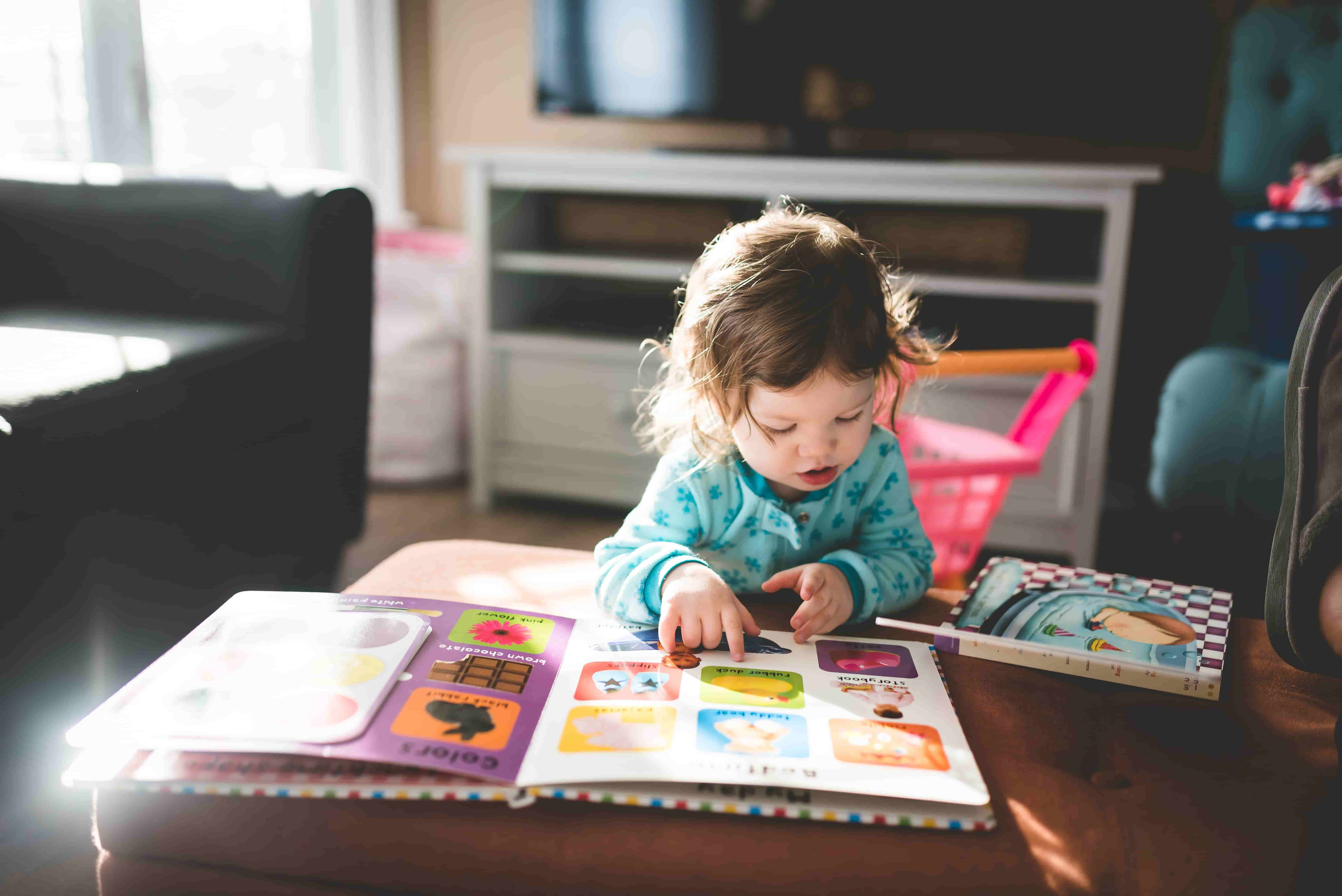 Jeune enfant qui regarde un livre imagé