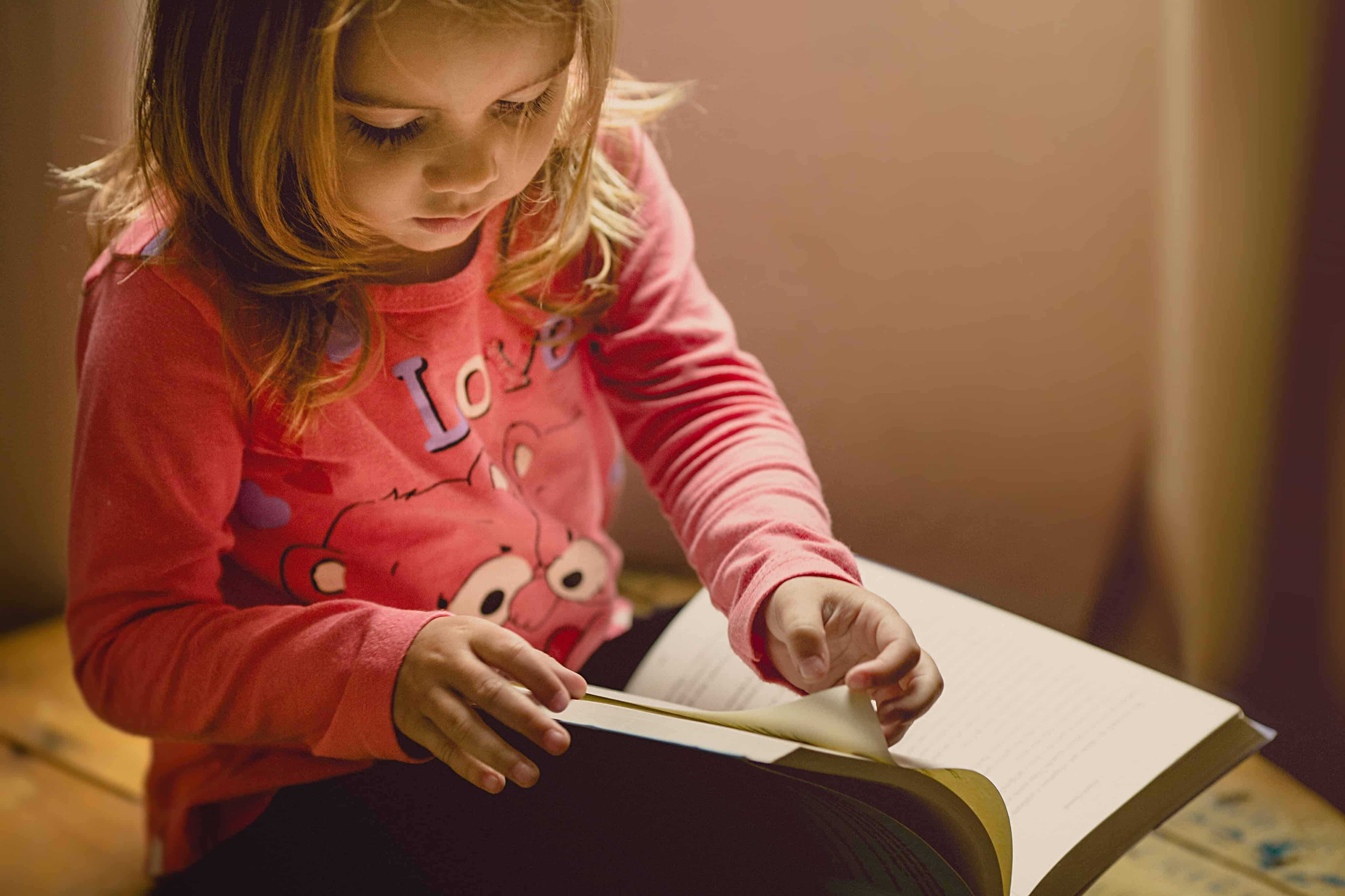 petite fille qui feuillette un livre