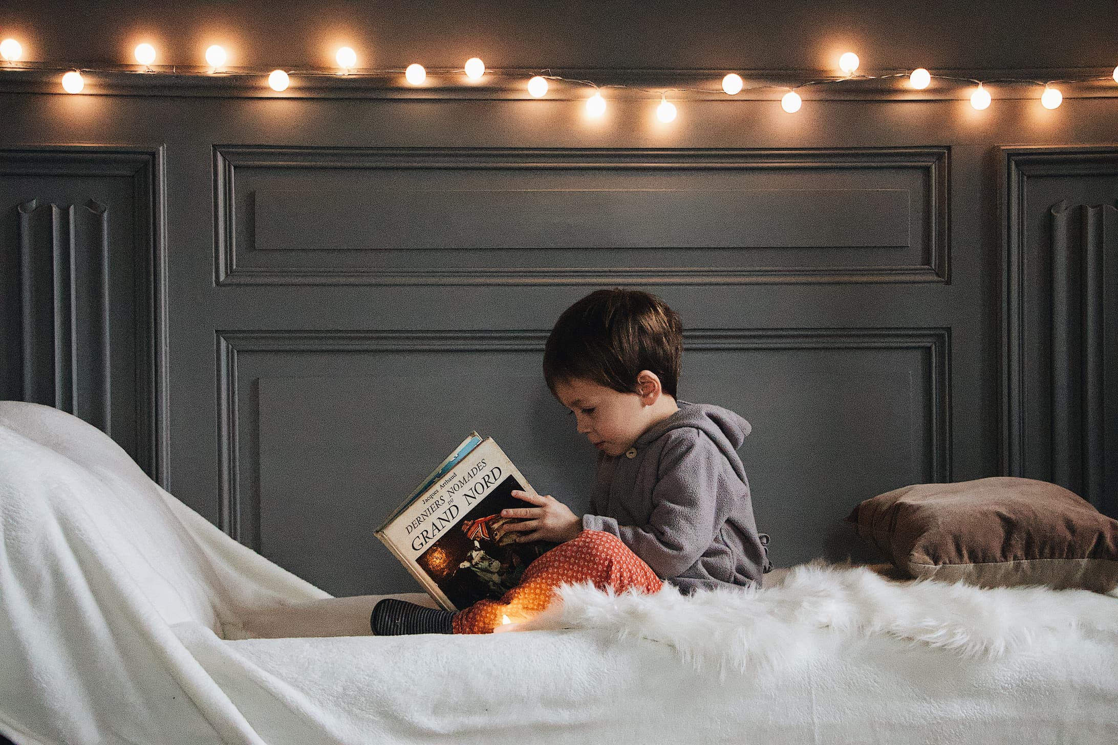 enfant lire un livre sur le lit